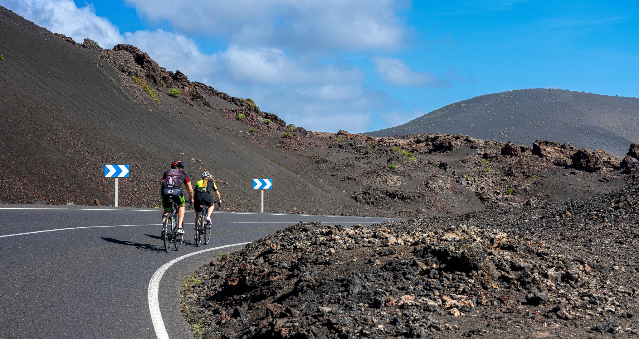 Ciclista su una strada di campagna, paesaggio vulcanico, Lanzarote, Isole Canarie, Spagna
