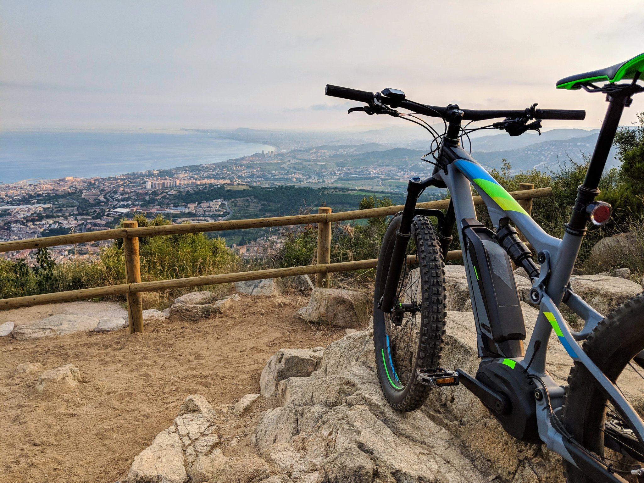 Elektrisches Mountainbike auf dem Gipfel eines Berges mit Blick auf den Ozean und das Tal in der Nähe von Barcelona, Spanien
