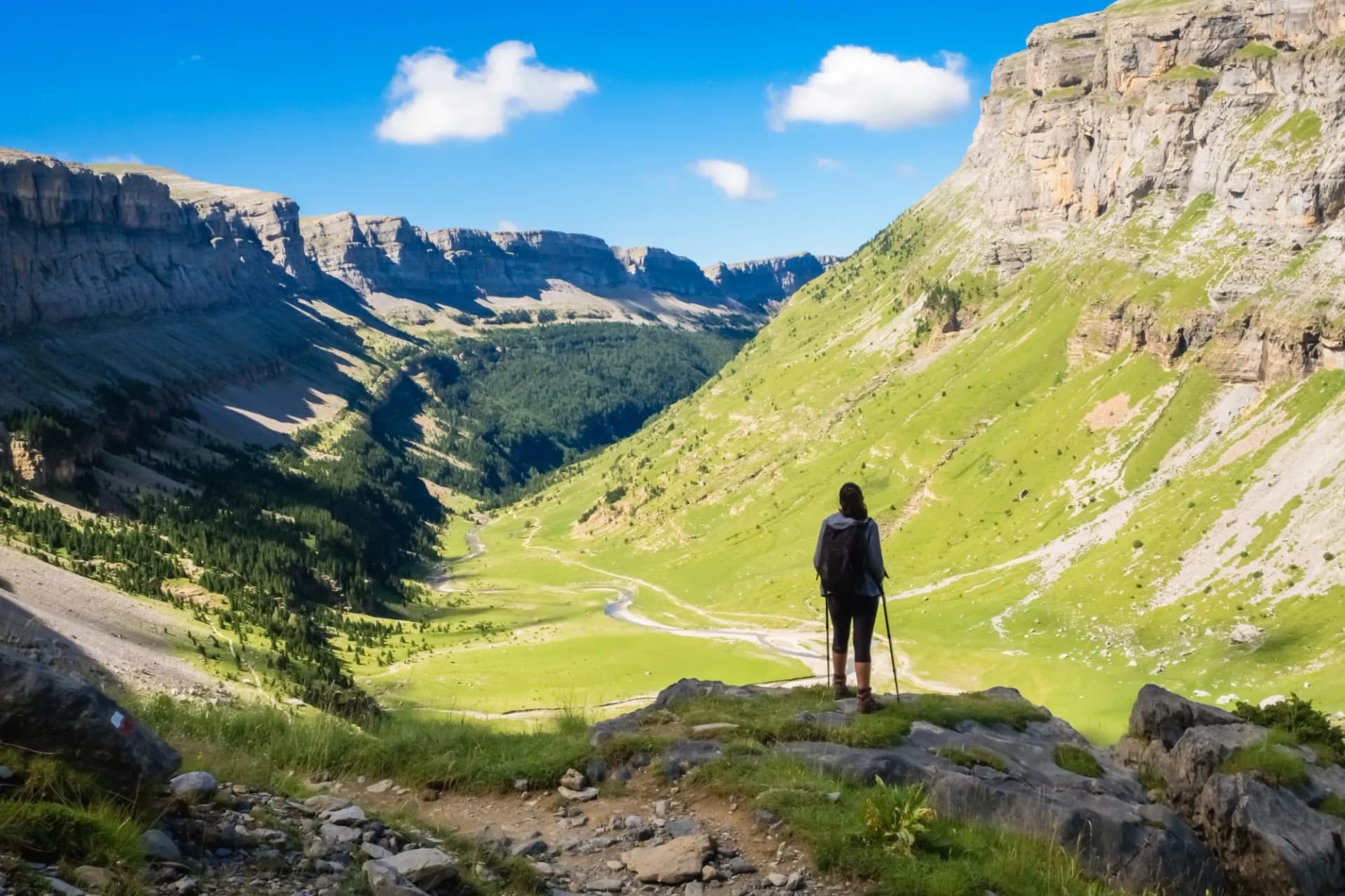 Hiker looking towards the valley of Ordesa National Park on a sunny day in Spain.