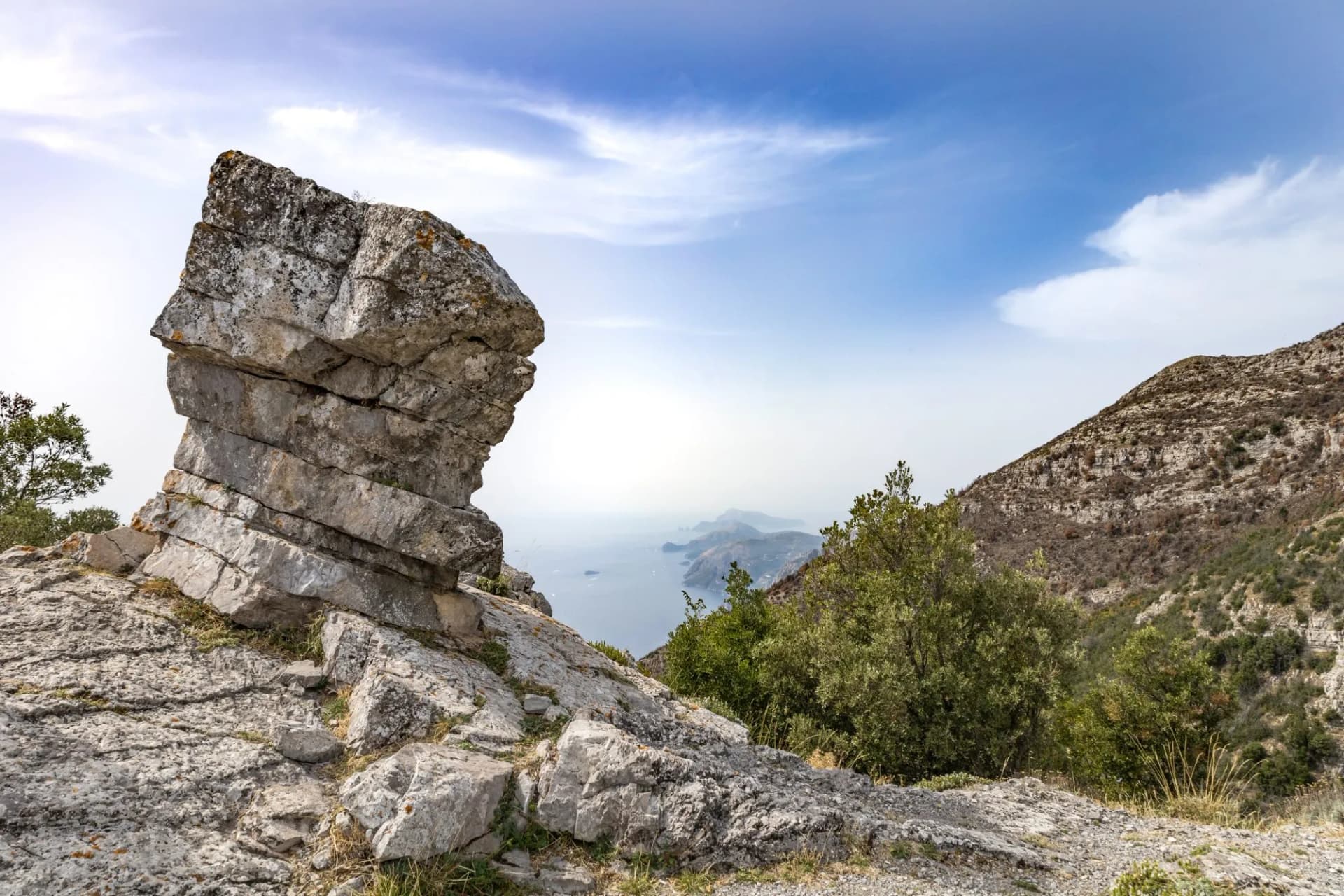 Capo Muro peack a rock to shape of mushroom on a path of the Amalfi coast with Capri in background. Agerola, Positano, Campania, Italy