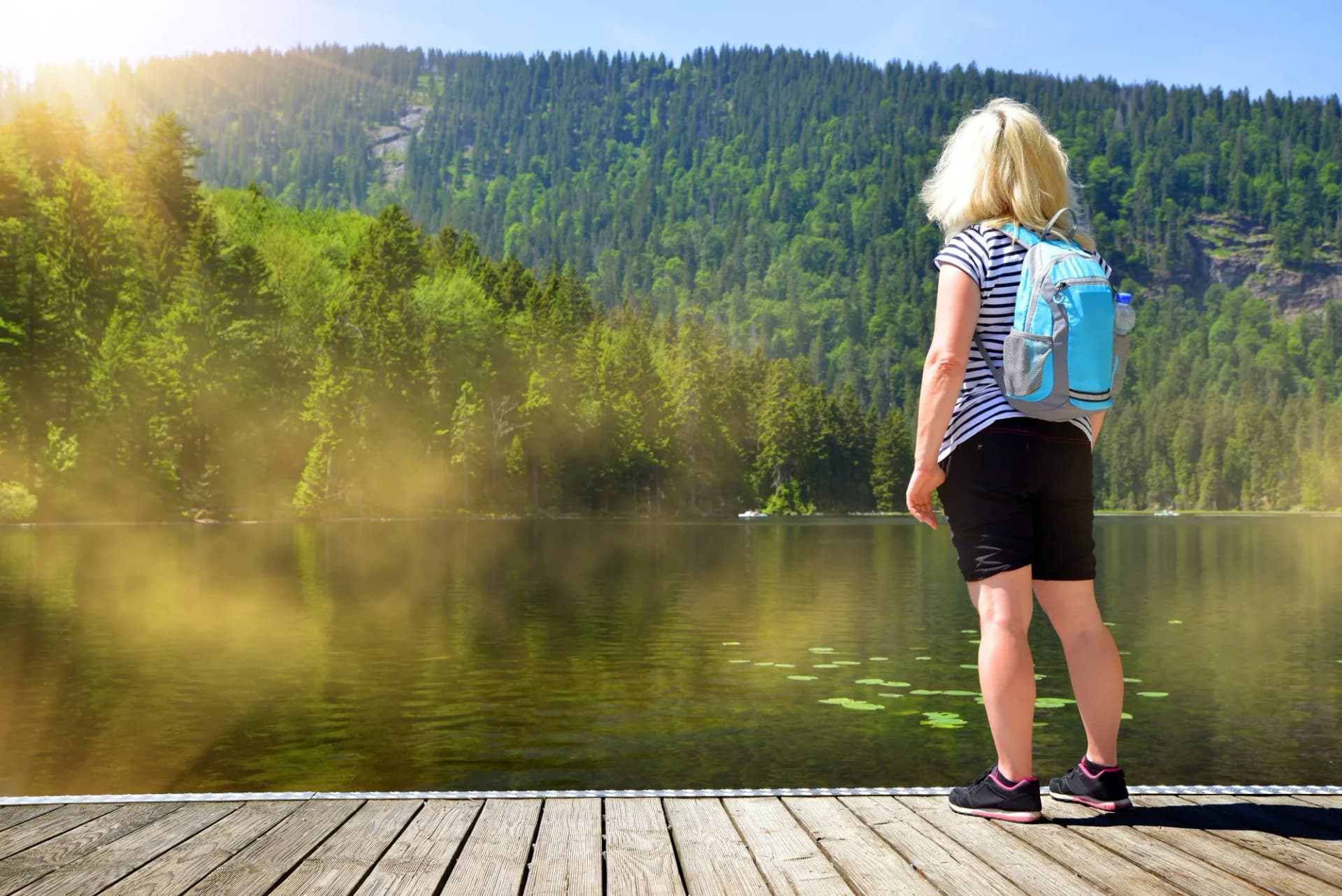 Woman by the moraine lake Grosser Arbersee in the National park Bavarian forest. Germany.