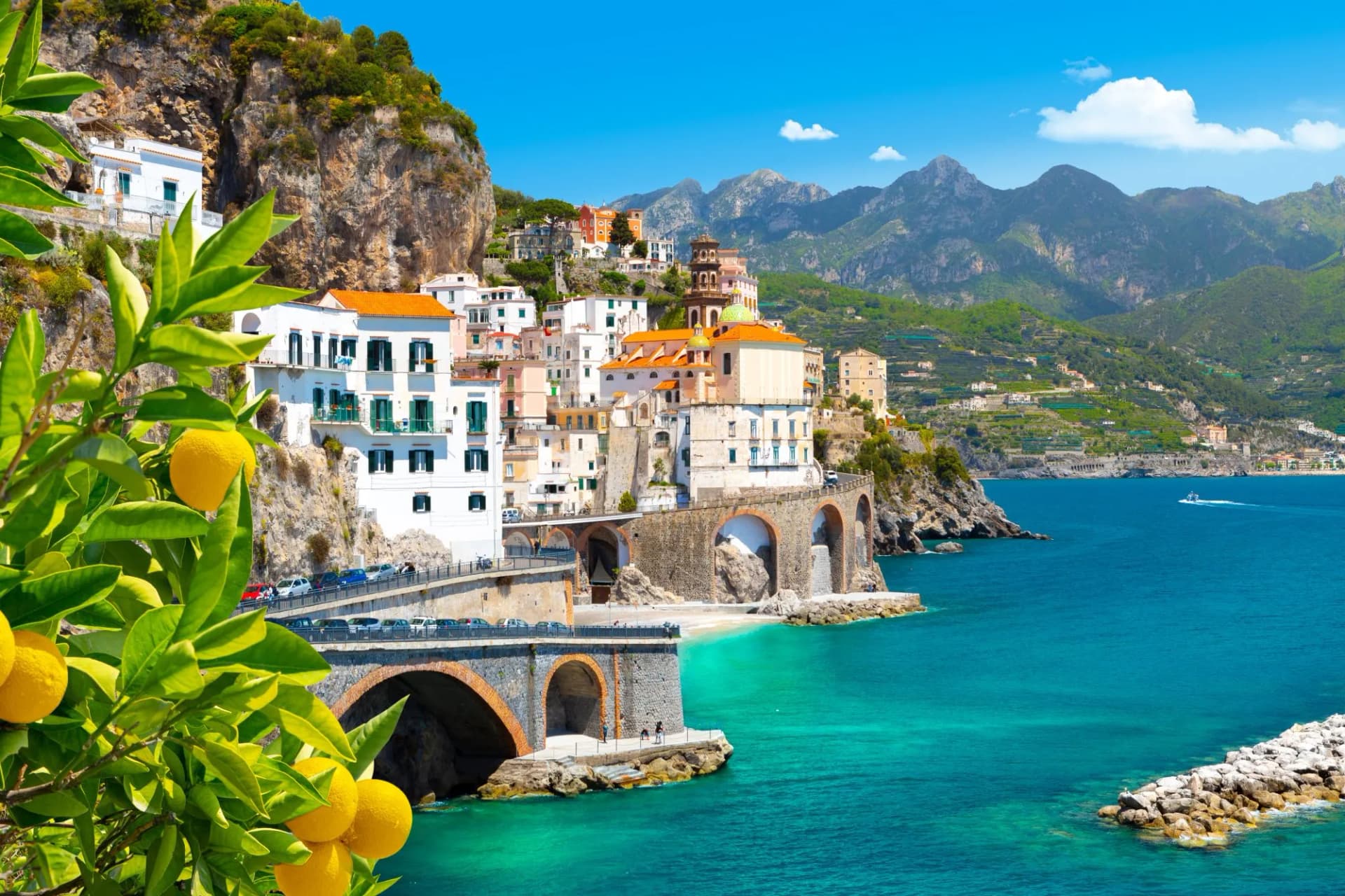 Lemons in foreground of Amalfi coast town with colorful buildings and mountains
