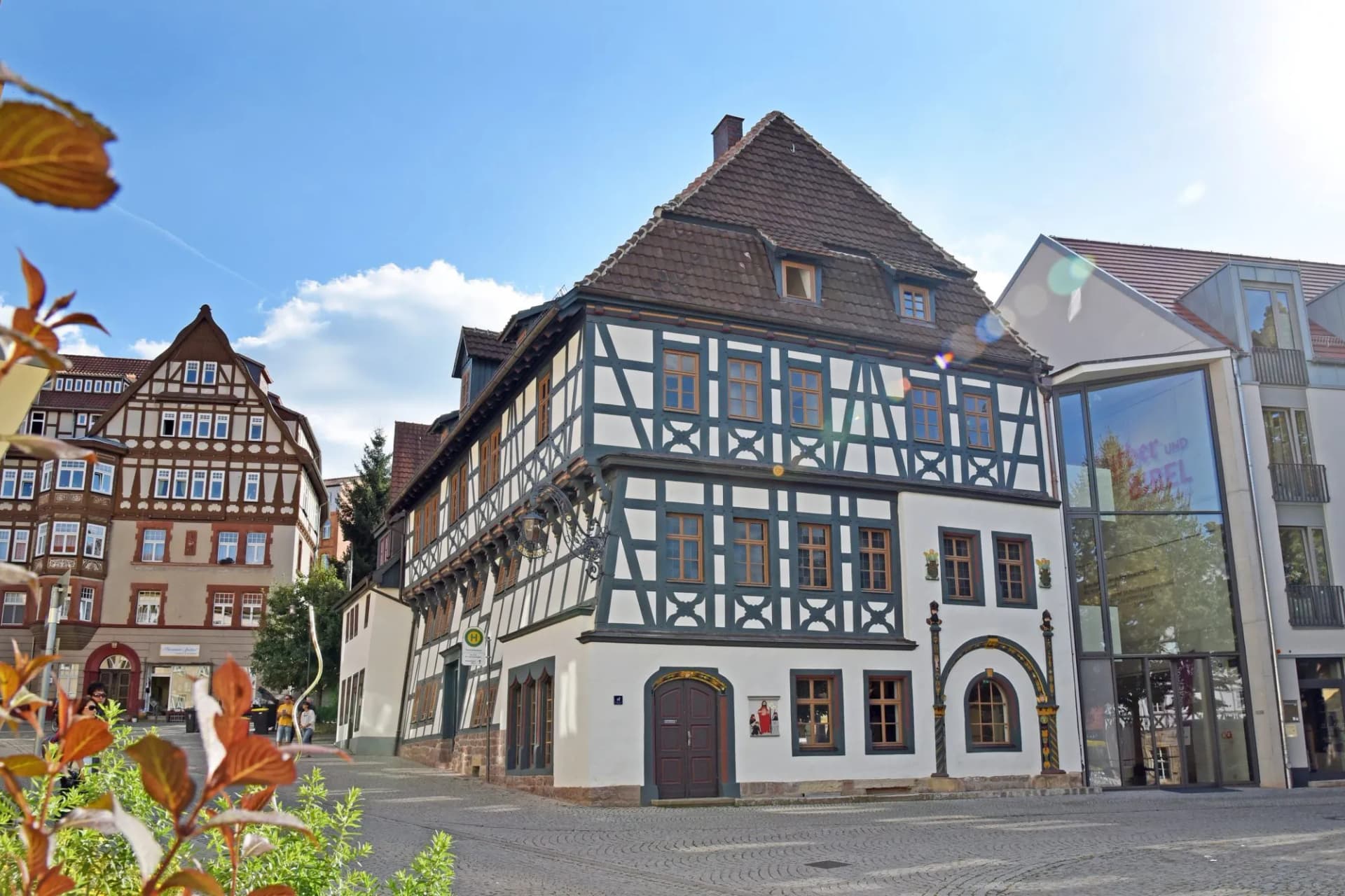 Lutherhaus building with half-timbered facade on cobblestone square under blue sky
