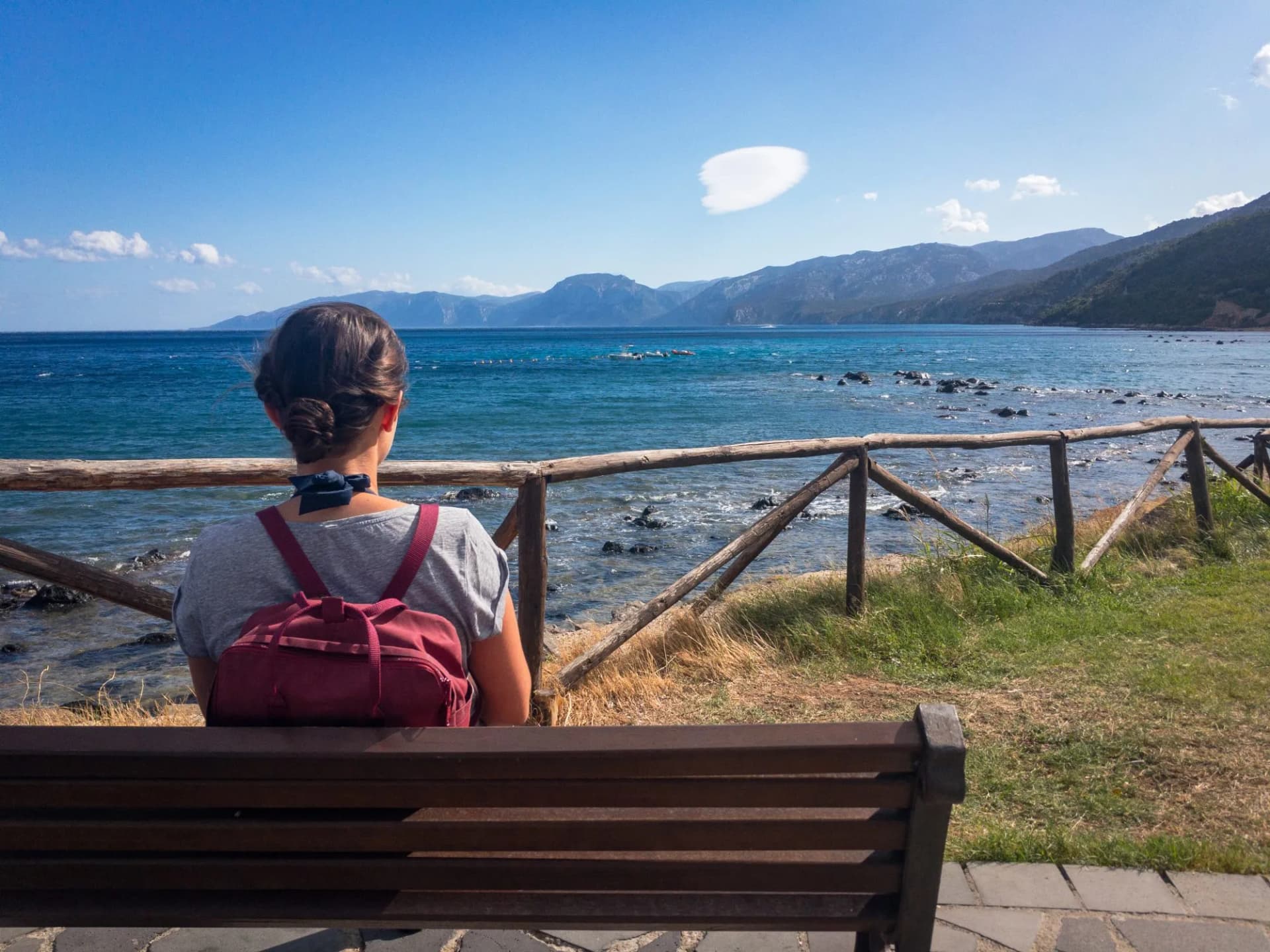 Woman looking at coastal landscape of Sardinia