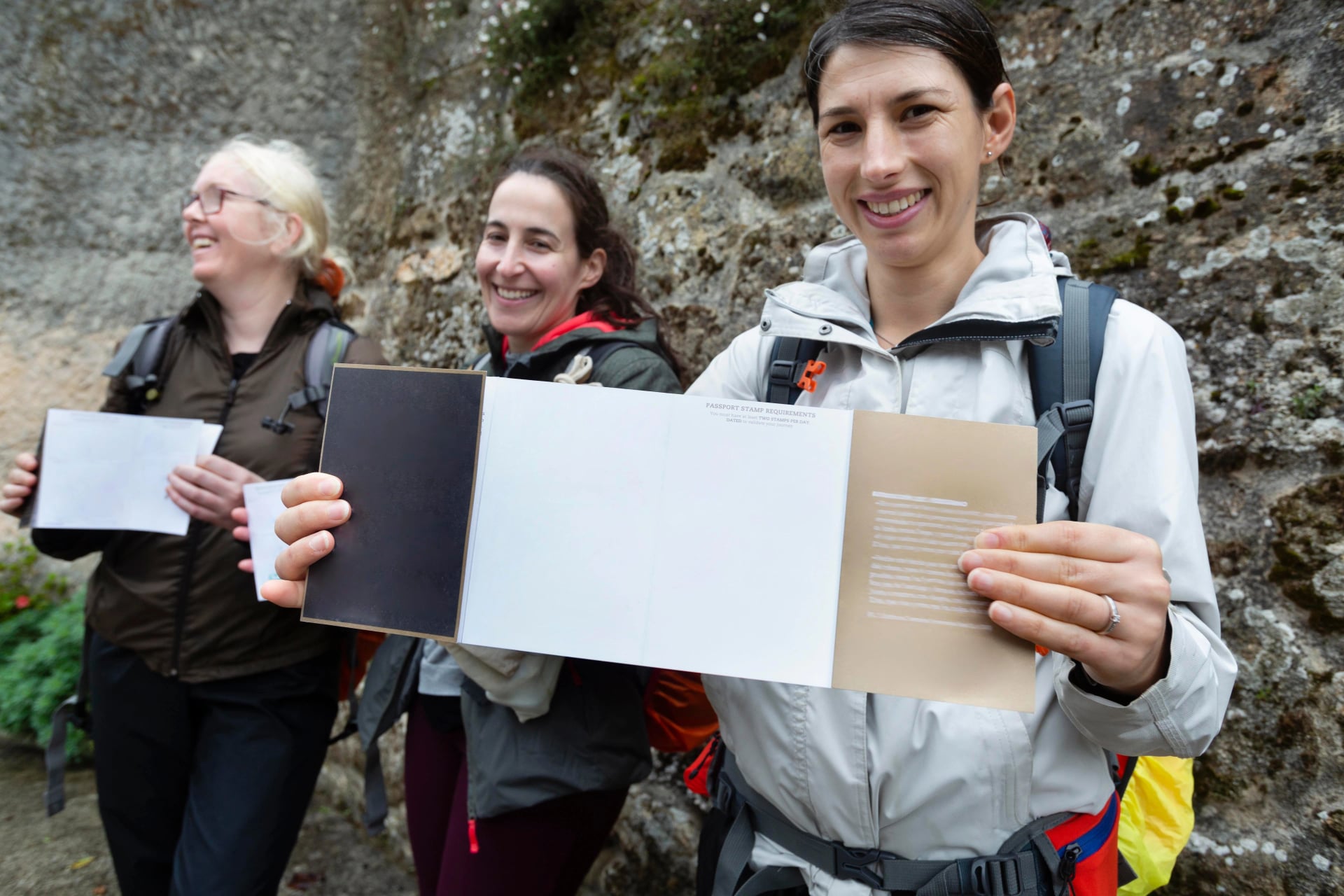 Three pilgrims show their pilgrim credentials. Camino de Santiago portuguese