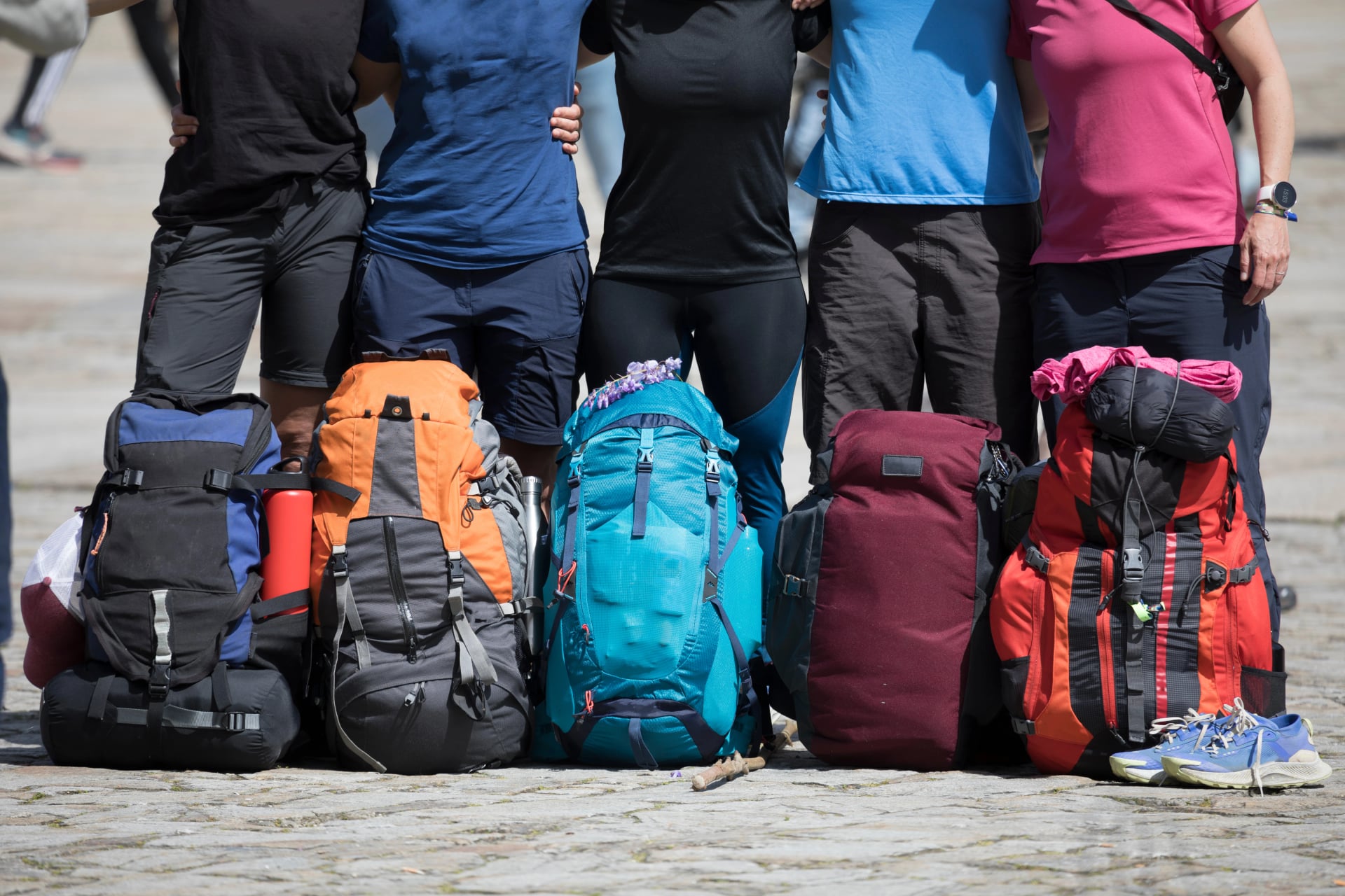 Pilgrims on the Camino de Santiago arrive at the Plaza del Obradoiro because they have finished their pilgrimage. A group of pilgrims with their backpacks in the Plaza del Obradoiro