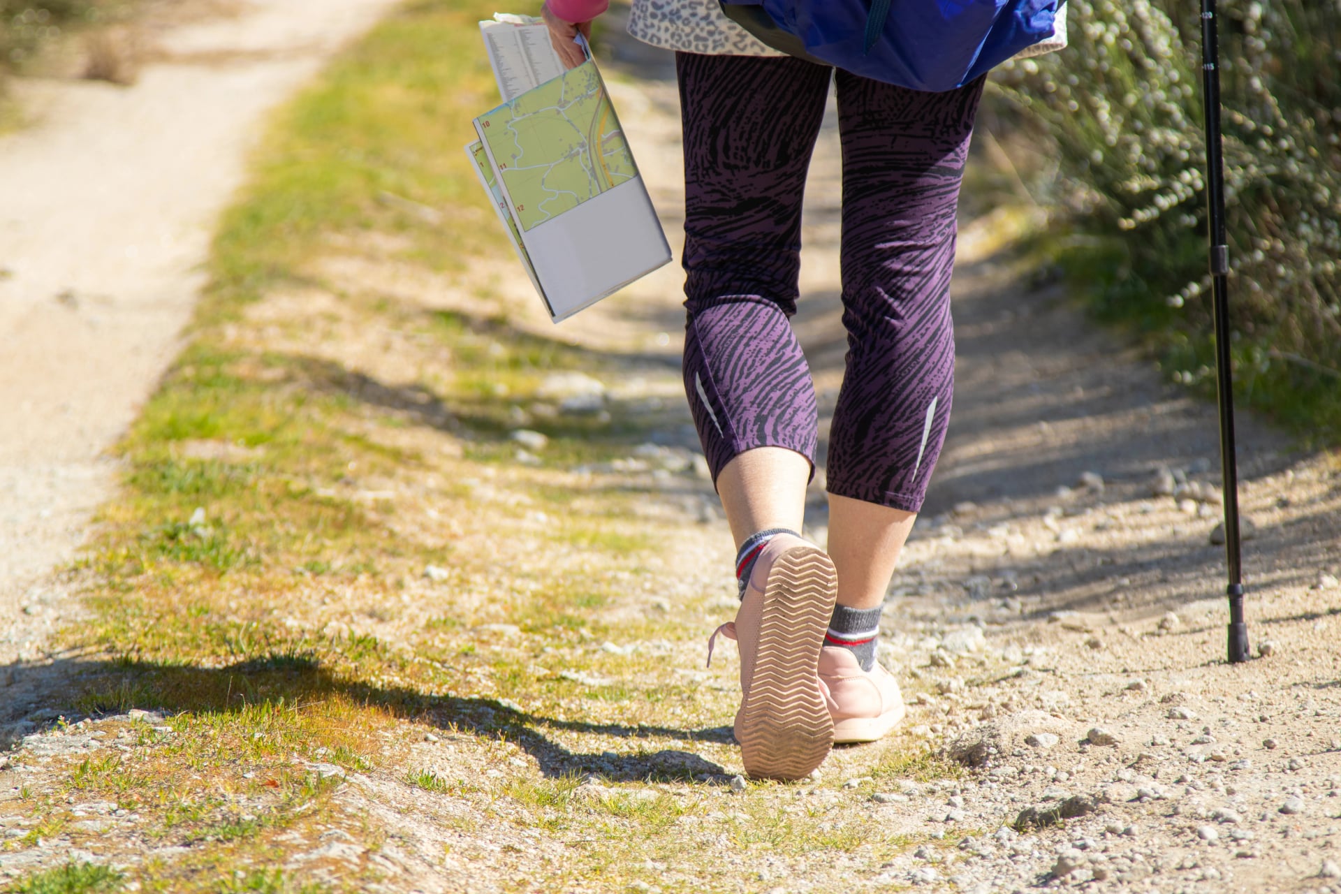 hiker feet on the trail with map and walking stick