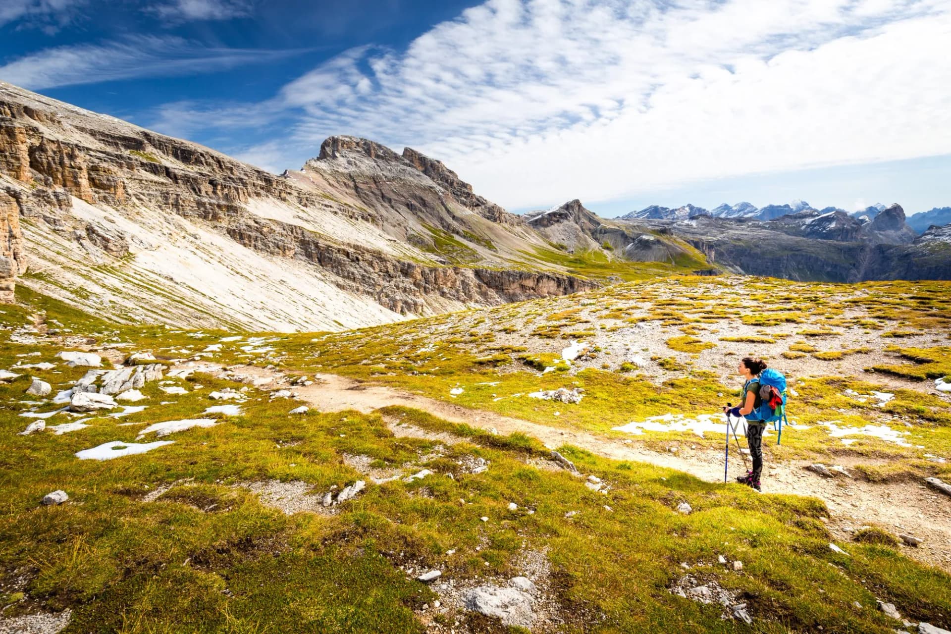 Backpacker female tourist hiking alone alpine mountains footpath Italy.