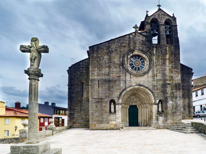 View of the church of Santa Maria del Azogue in Gothic style built in the second half of the XIV century, and stone cross views from the Plaza de Andrade in Betanzos, Galicia, Spain