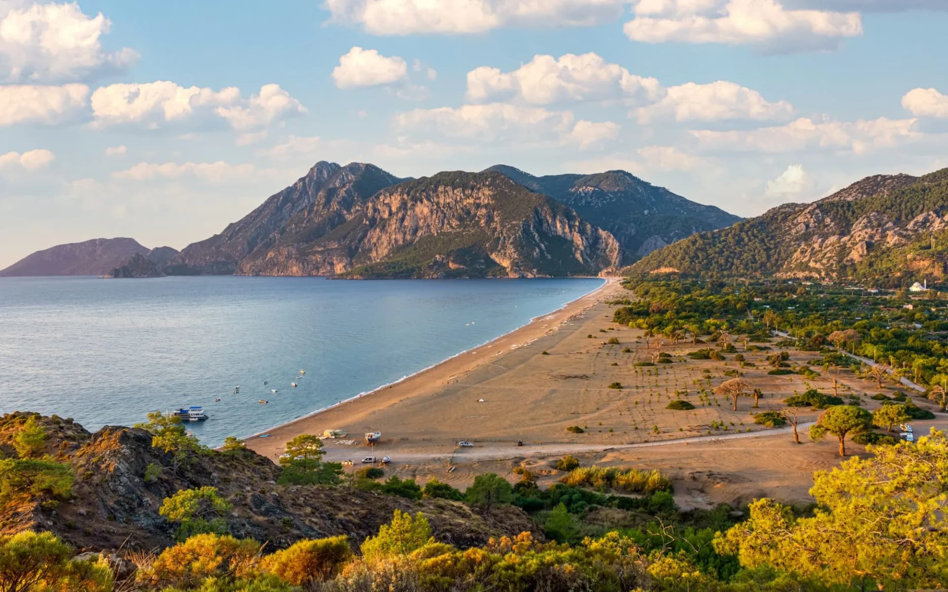 Picturesque beach in Cirali village. Sea mountains and pine trees on the beach. Kemer, Antalya, Turkey.