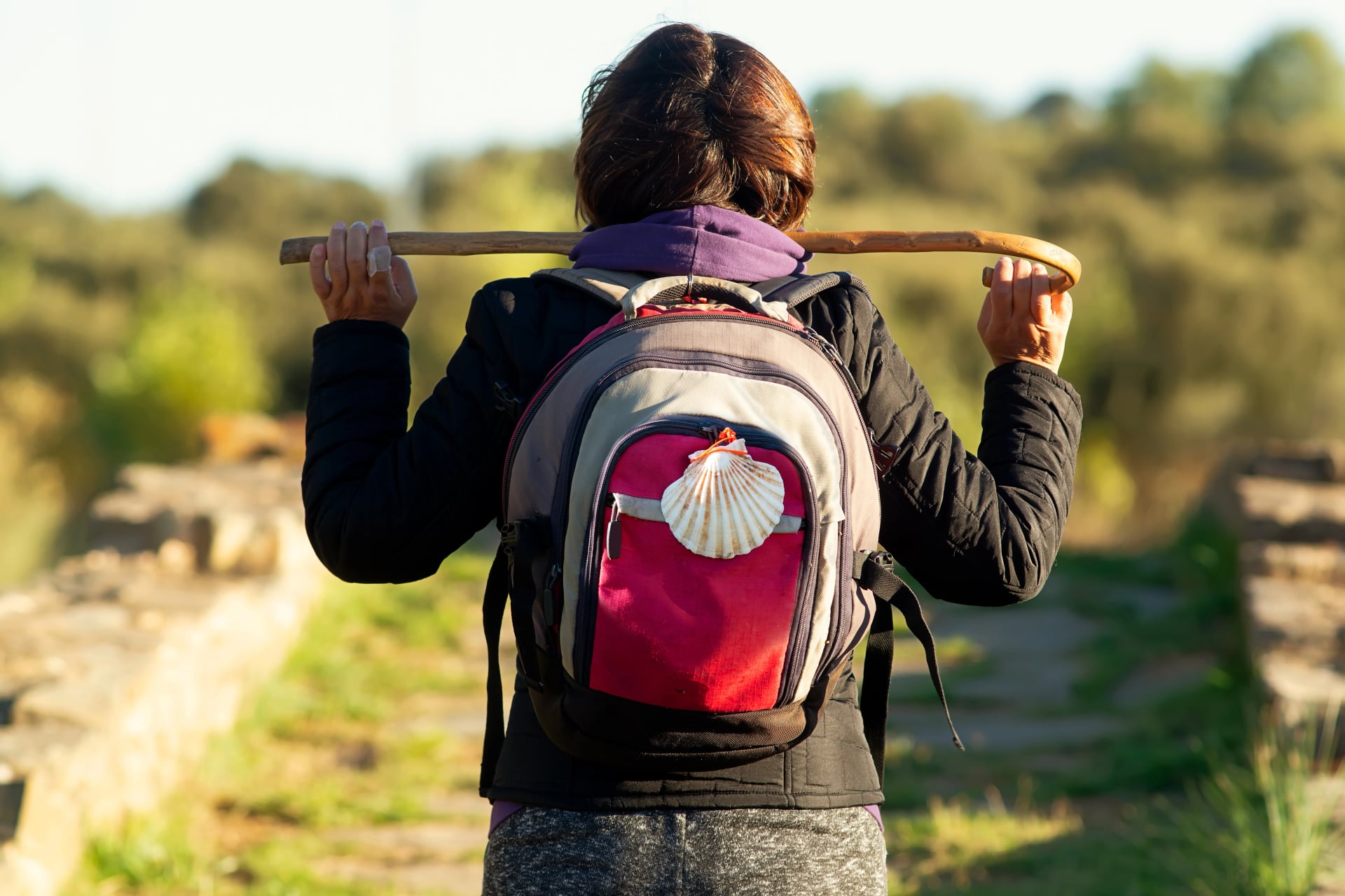 pilgrim woman in roman bridge of Valimbre on Camino de Santiago through the Via de la plata , Leon province, Spain
