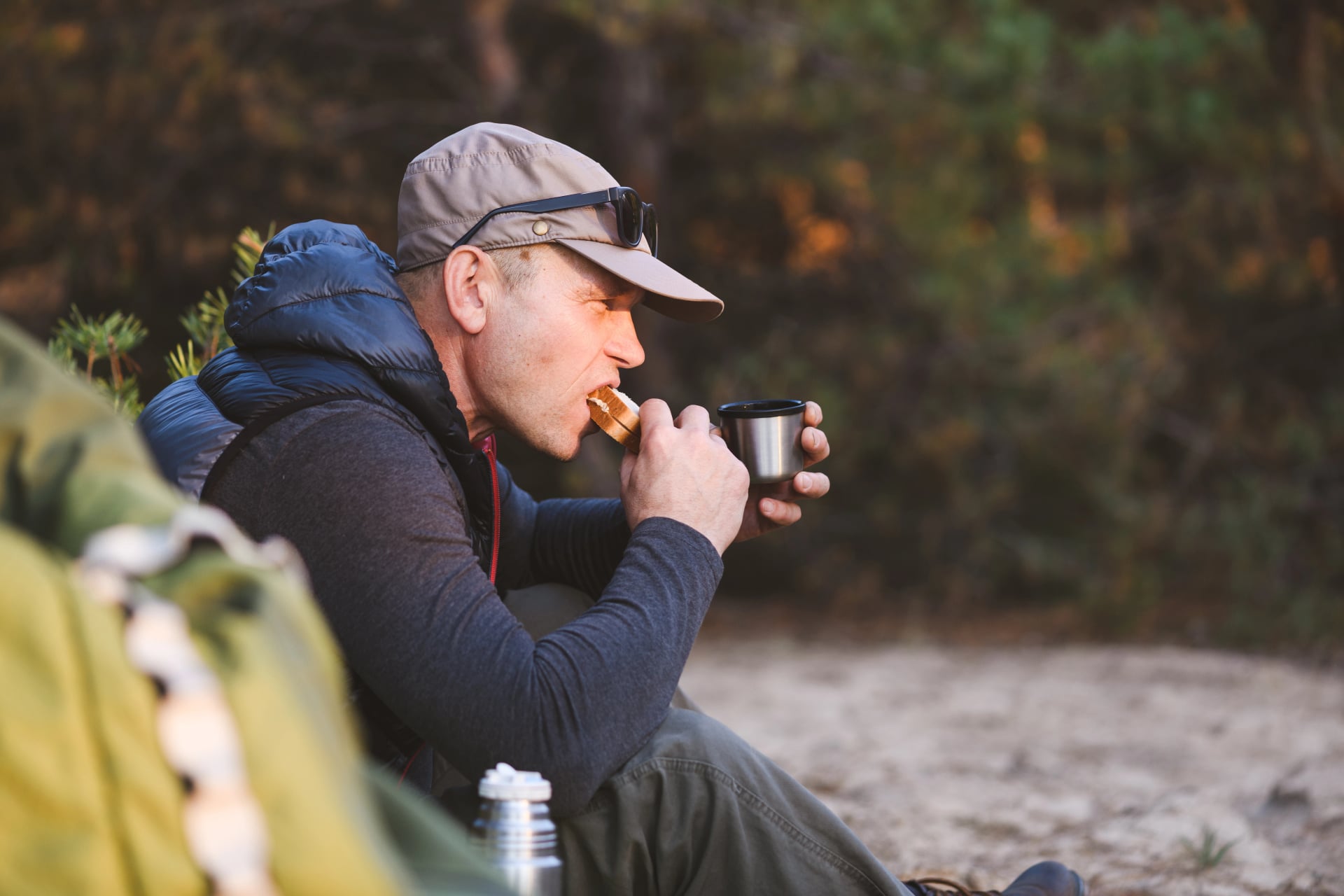 Mature male hiker eating sandwich close up