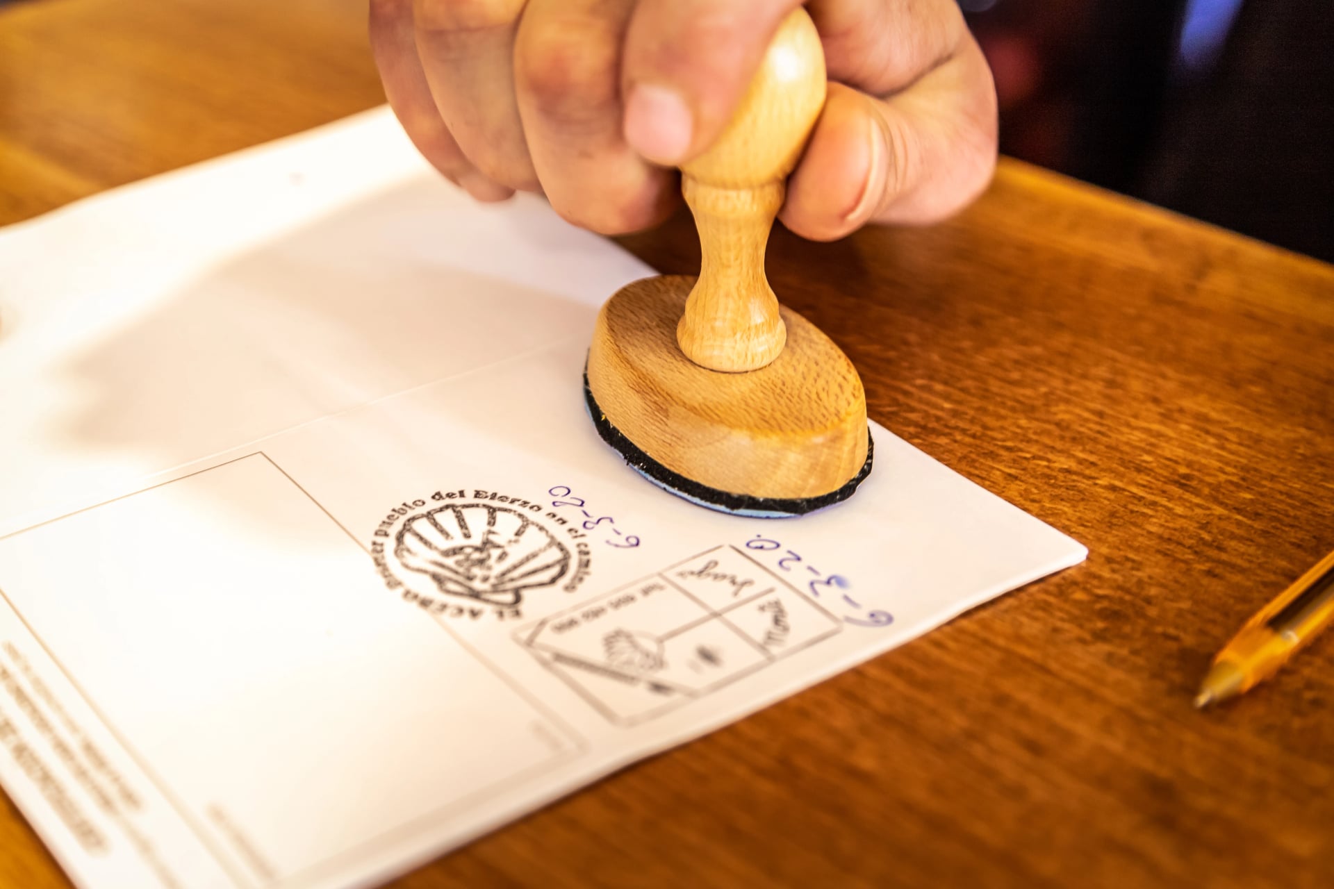 Albergue Hostel Tenant Putting Stamp in Pilgrim Passport Credencial on Camino de Santiago St James Way Pilgrimage Trail