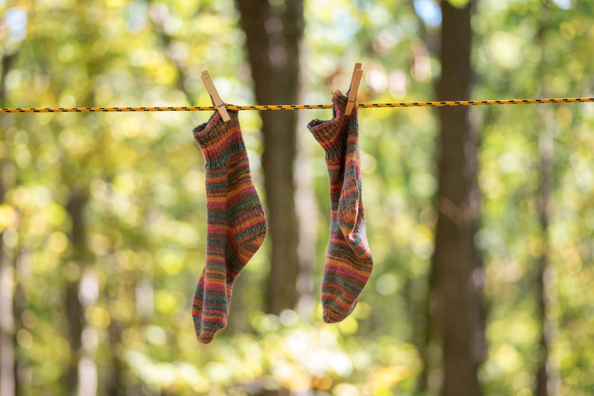 Colorful handknit socks hanging to dry on the clothesline
