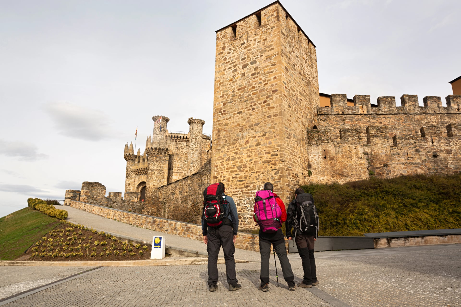 Peregrinos del camino de Santiago viendo el castillo de Ponferrada, León.