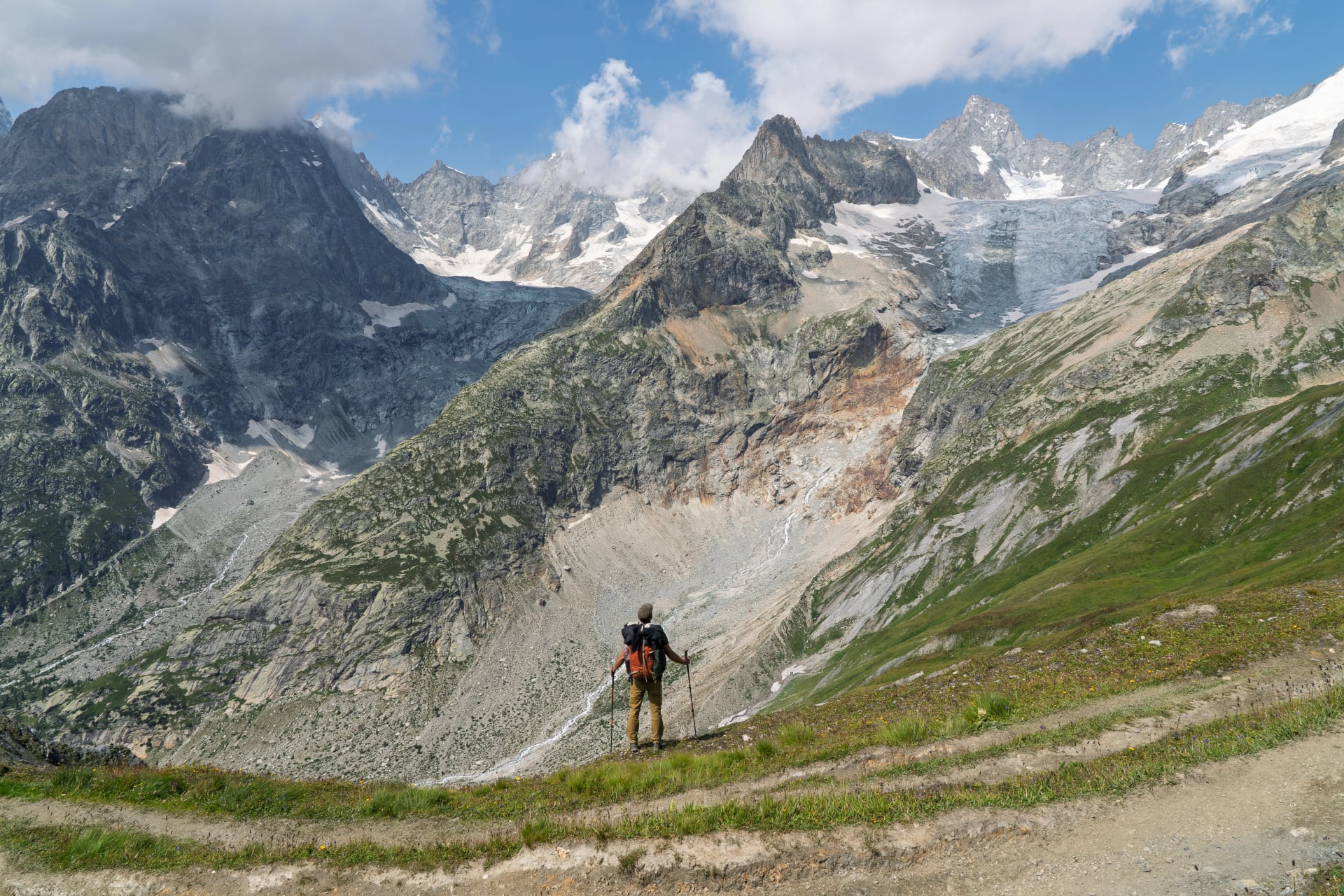 Hiker admiring massive glacier and peaks on Tour du Mont Blanc, Switzerland