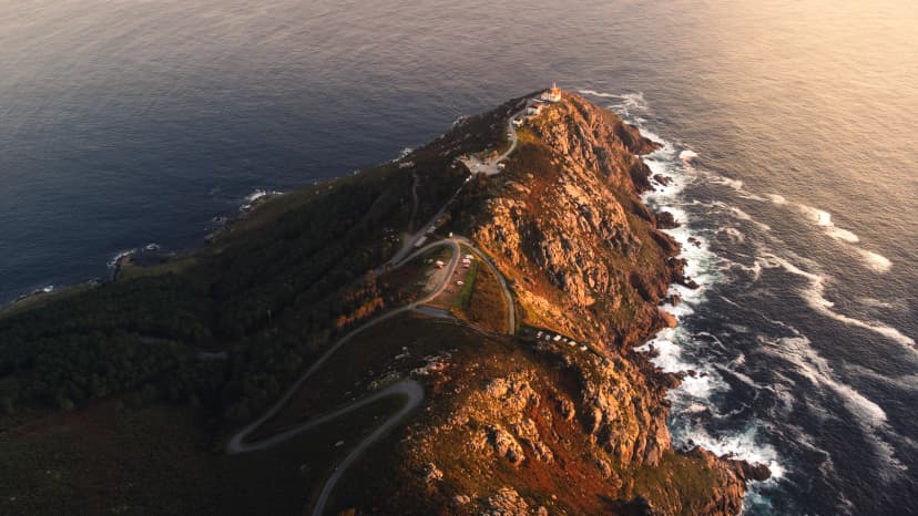 Cape Finisterre Lighthouse the end of the earth famous tourist destination in Galicia northern Spain region, aerial drone footage at sunset