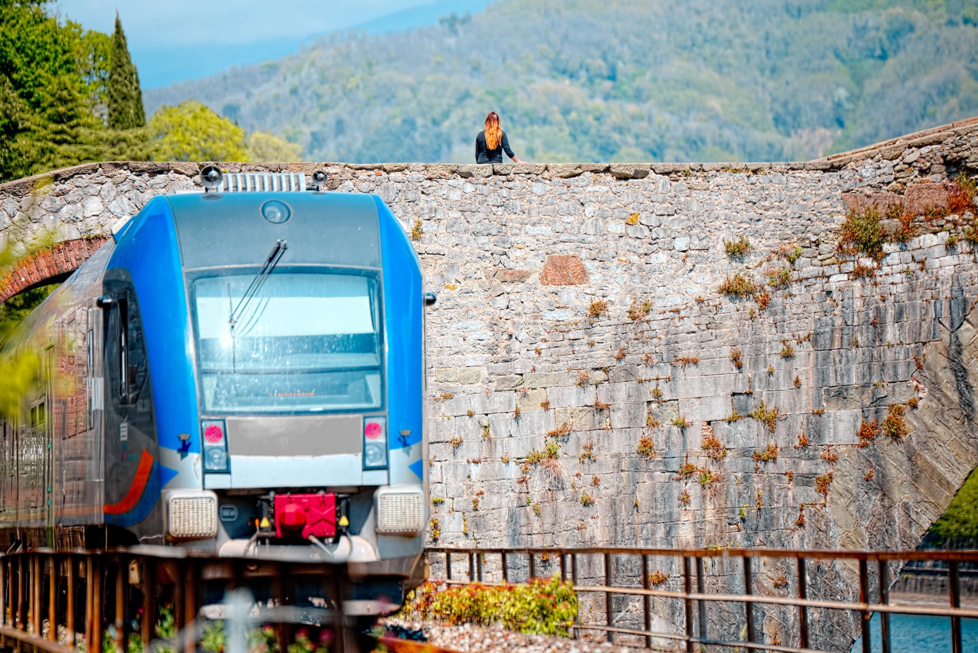 Girl waits for the last train passing under the Bridge Of The Devil, Lucca, Tuscany