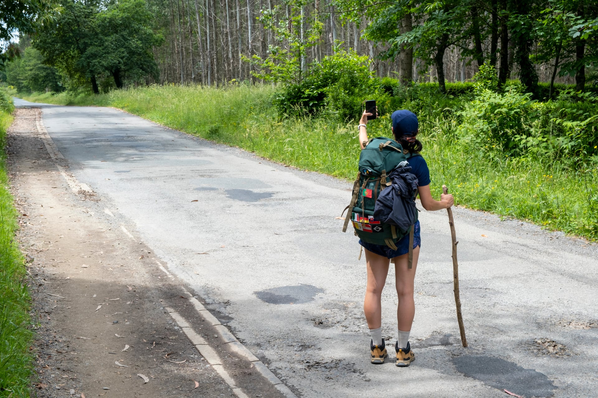 Young woman pilgrim taking a selfie on a trail of the way of saint james. Camino de Santiago