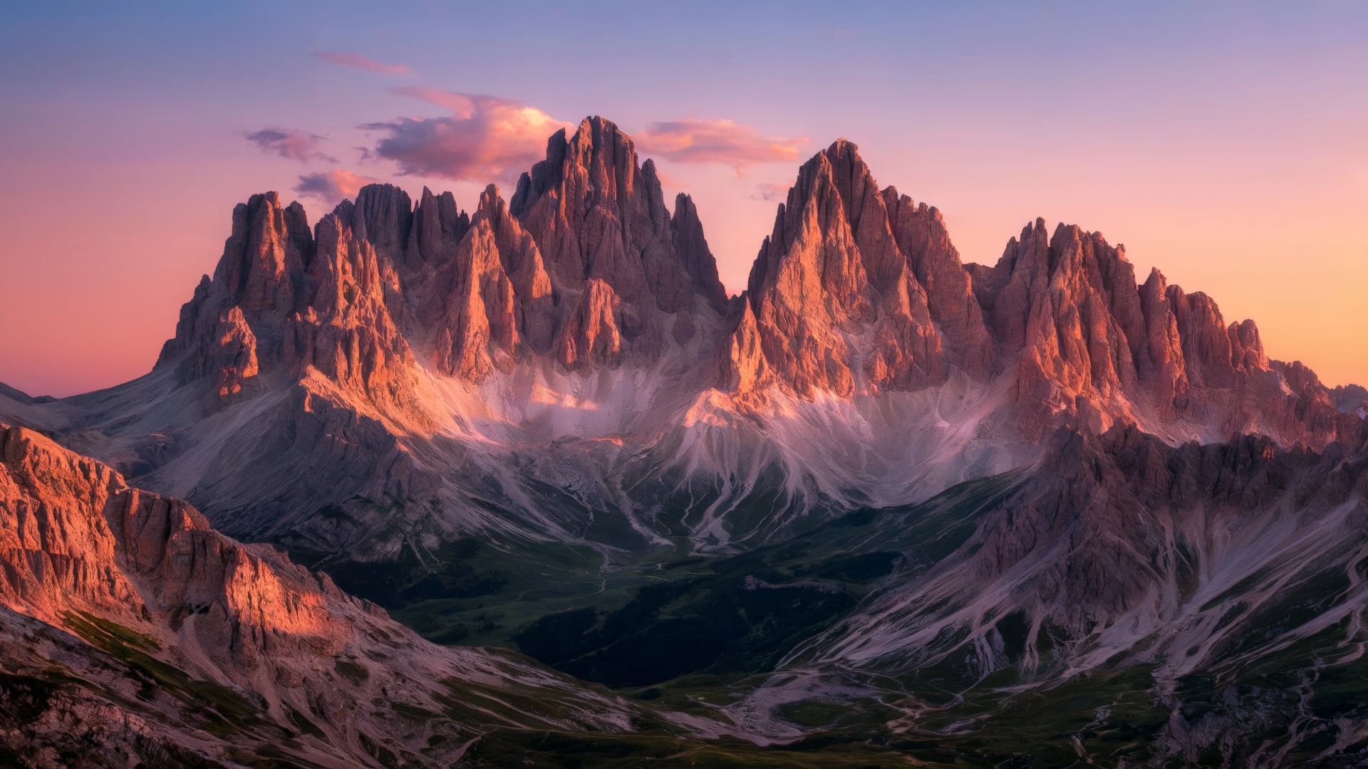 The Dolomites Italy. The alpenglow at sunset over the Dolomites, with the mountain peaks glowing pink and orange under clear skies