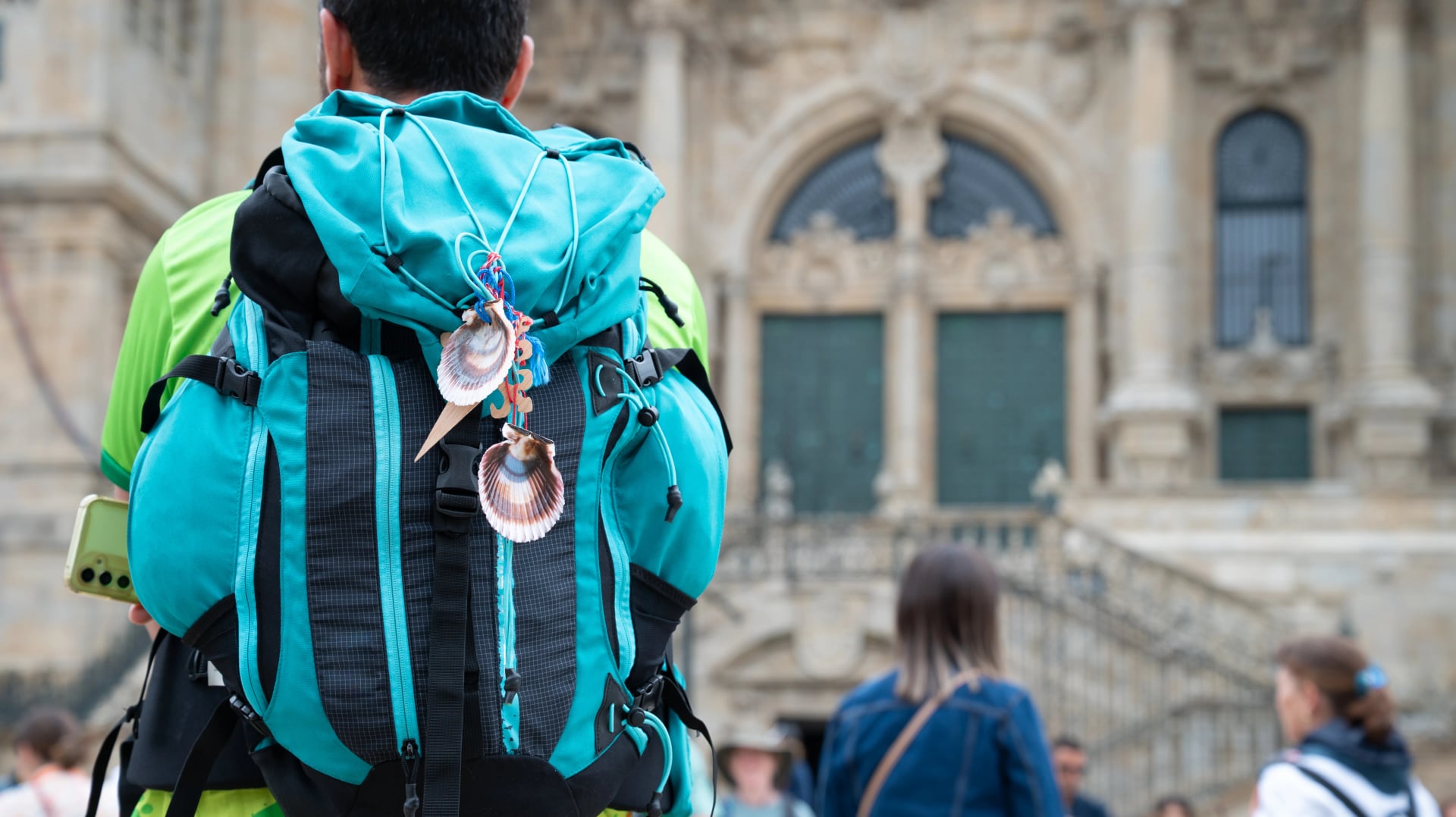 Pilgrim with Blue Backpack Facing Santiago de Compostela Cathedral