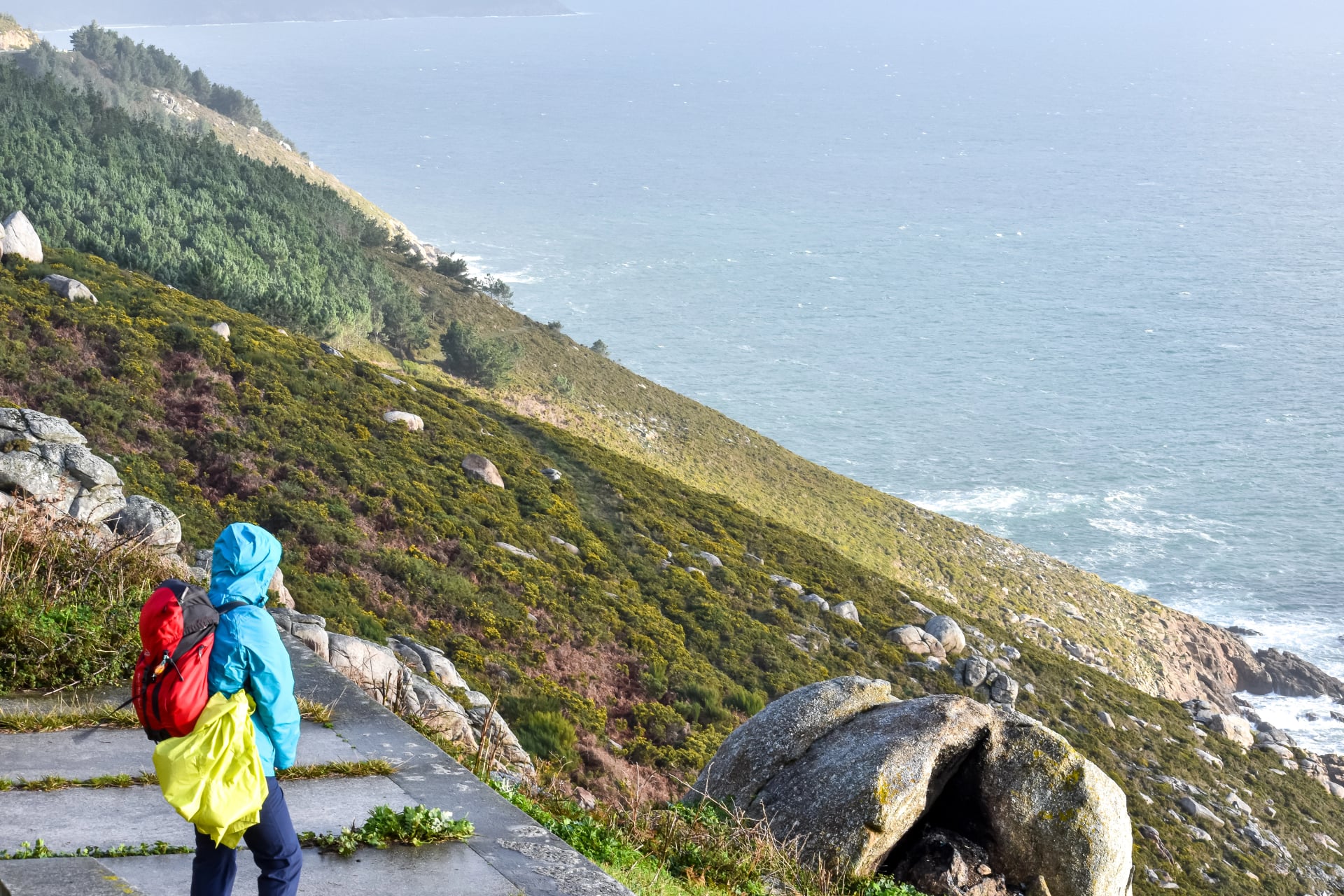 Pilgrim of the Camino de Santiago looking at the sea on the coast of death in Finisterre, Galicia, Spain