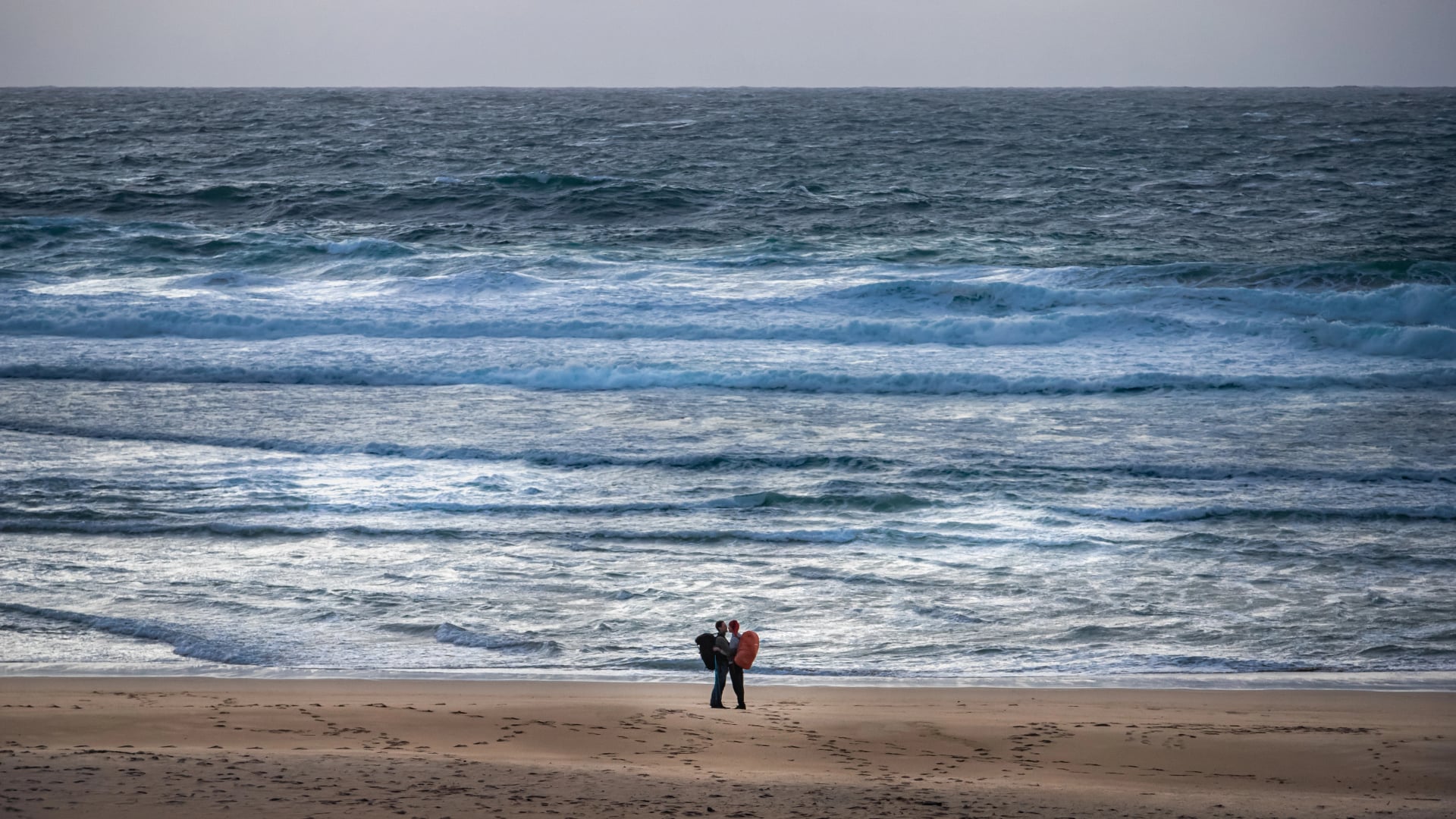 pilgrim couple embracing at the Atlantic Ocean in Finisterre at the end of the Camino de Santiago