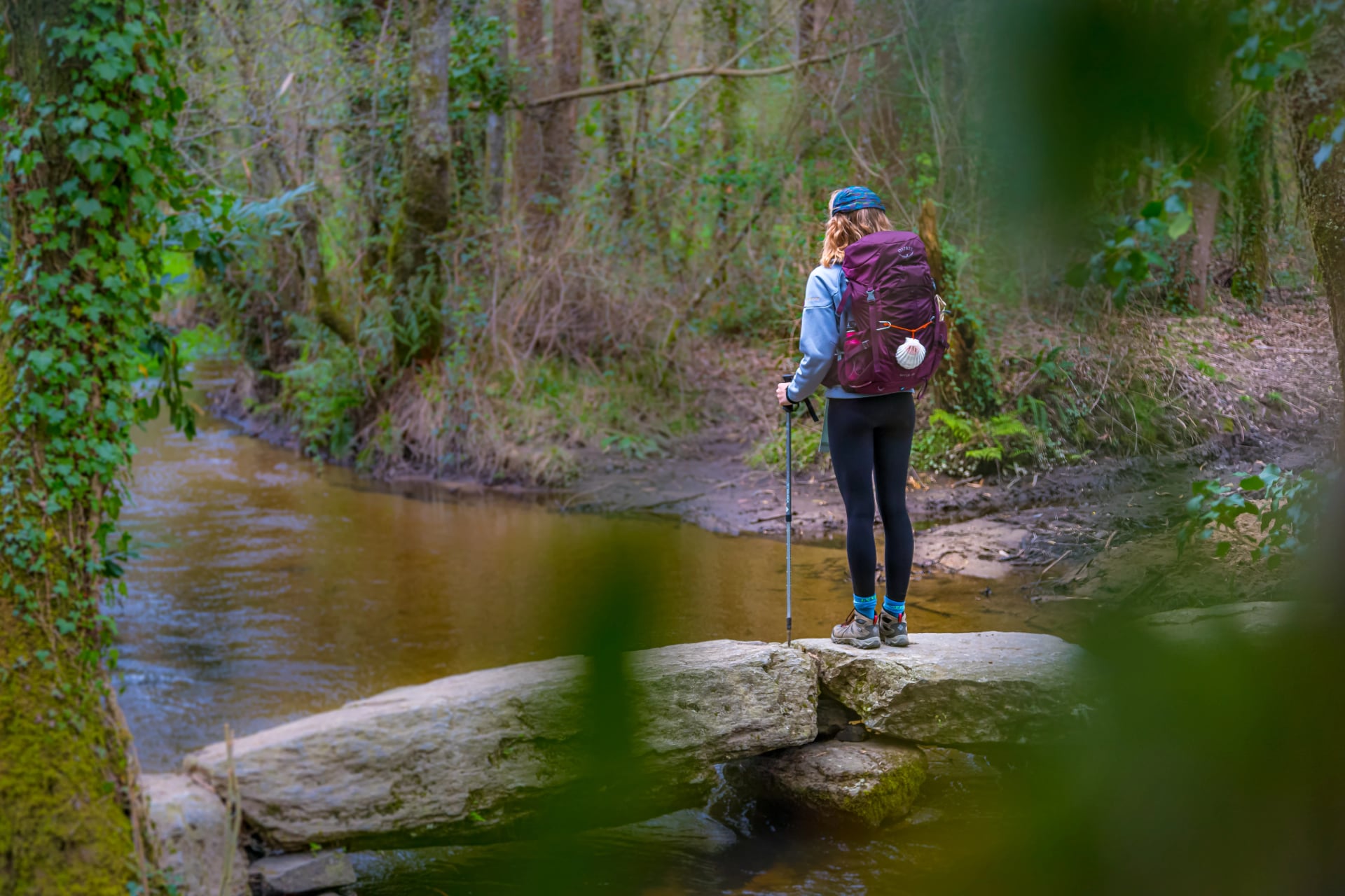 Pilgrim Girl Hiking on a Stone Bridge in Galicia Spain along the Way of St James Camino de Santiago Pilgrimage Trail