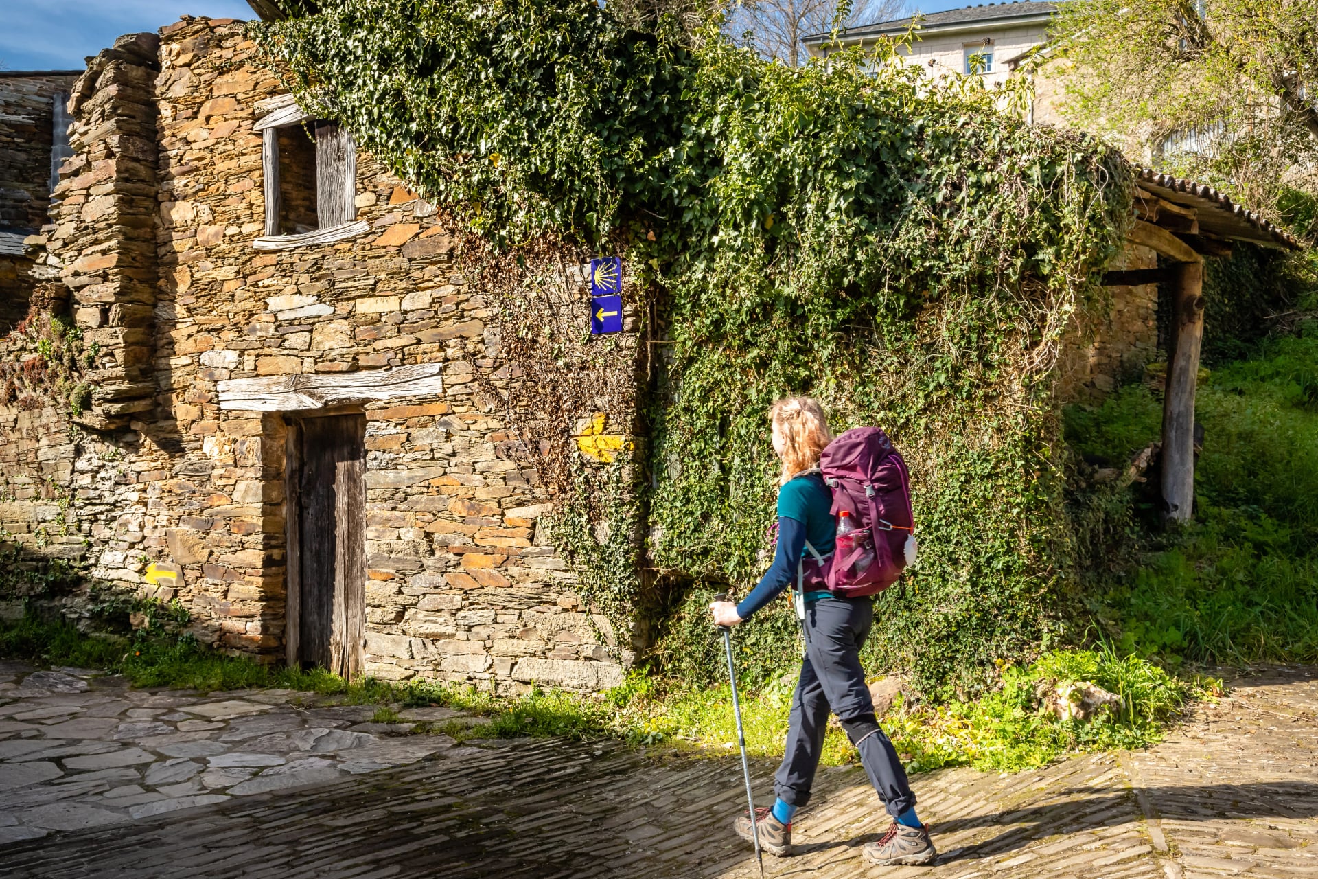 Pilgrim Girl Walking in Town of Triacastela Galicia Spain along the Way of St James Camino de Santiago Pilgrimage Trail