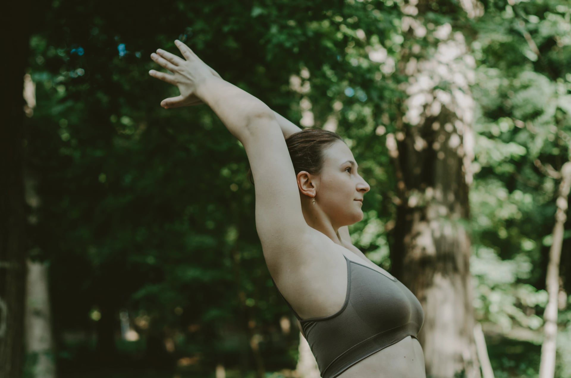 Woman doing upper body yoga stretch chest opener outdoors