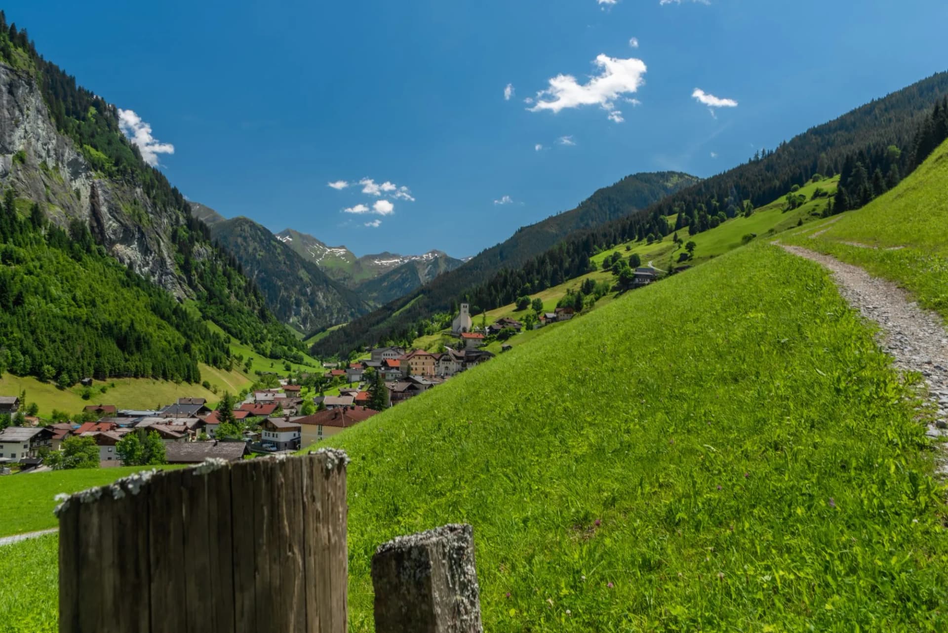 Summer valley with Grossarler Ache small river and blue cloudy sky