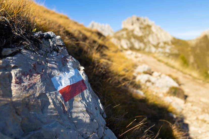 Trekking direction indicators in focus in the foreground. The background of the mountains is blurred. Dolomites Italy