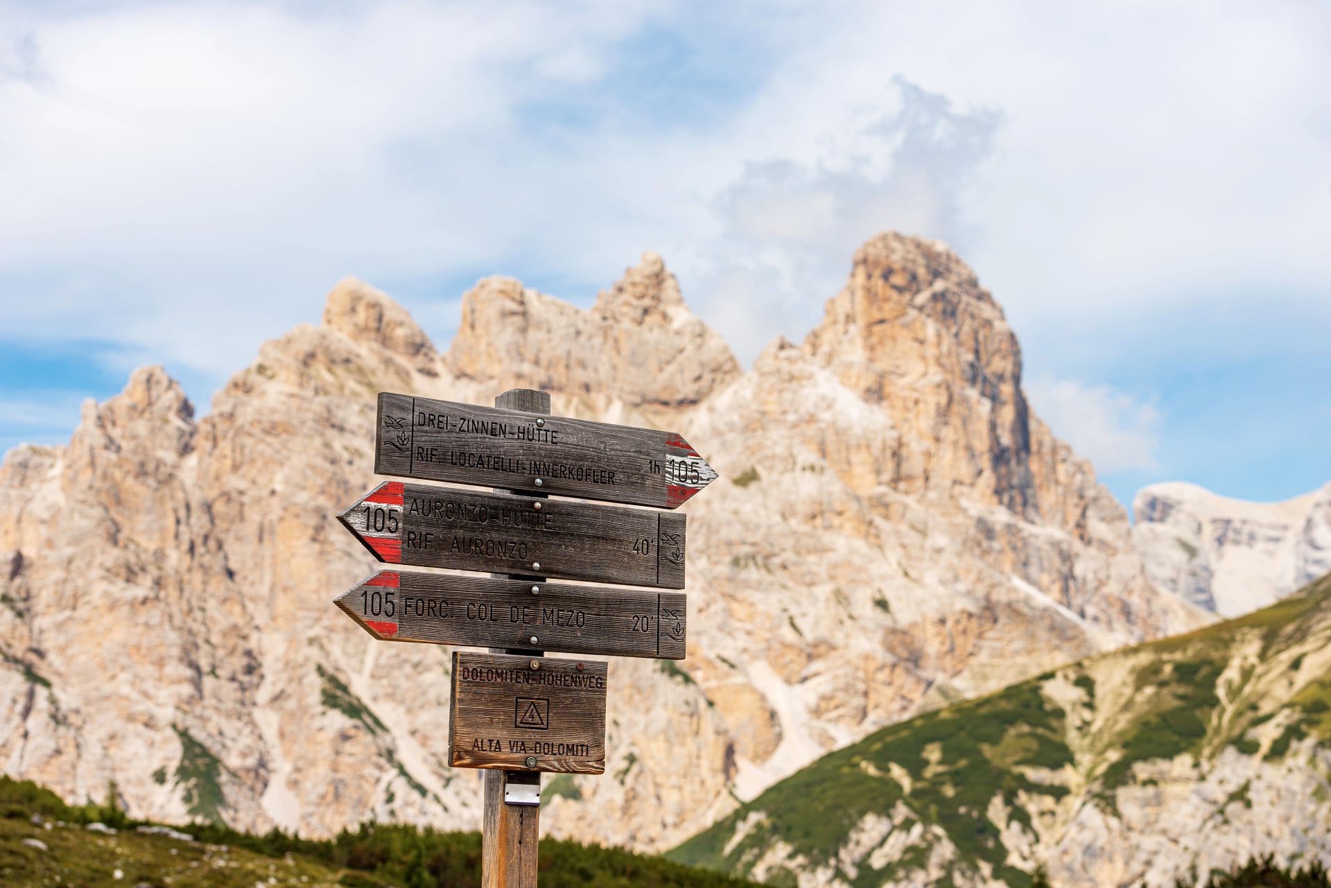 Directional trail signs in Sesto or Sexten Dolomites in front of Tre Cime di Lavaredo. On background the Mountain Peak of Monte Rudo and Croda dei Rondoi, Trentino-Alto Adige, Italy, Europe.