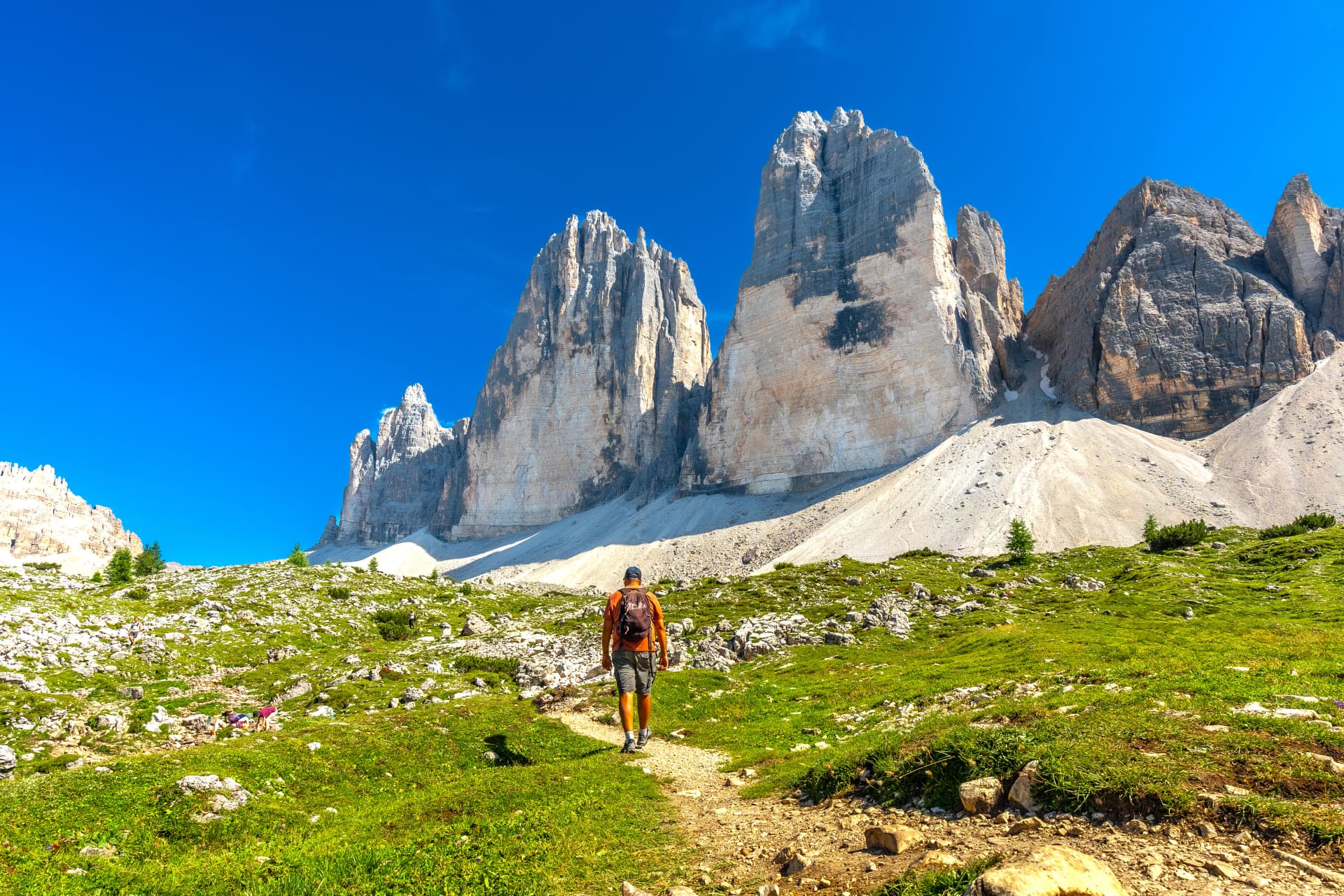 Tourist hiking on scenic trail to tre cime di lavaredo in the italian dolomites