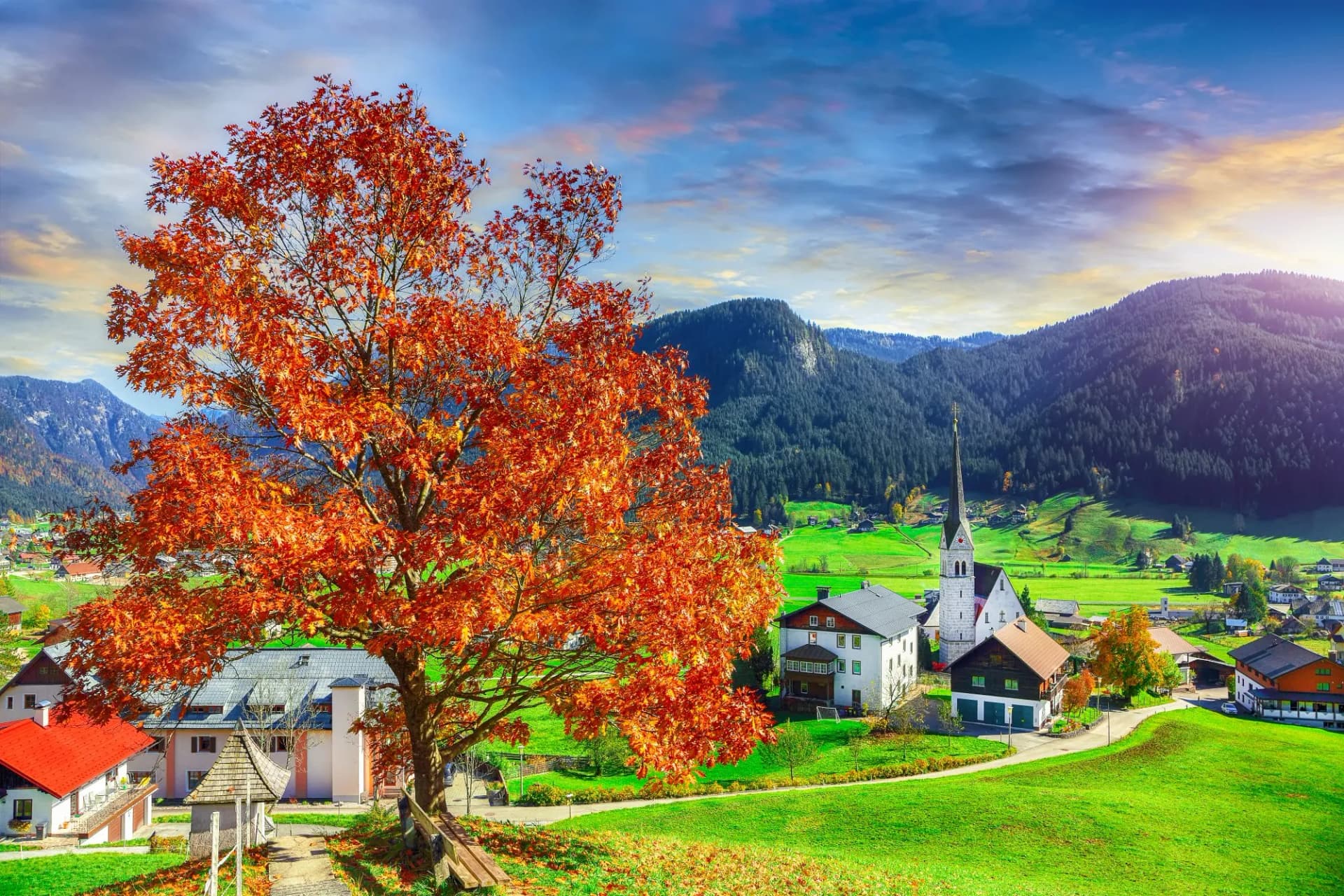 Alpine green fields and traditional wooden houses view of the Gosau village at autumn sunny day.