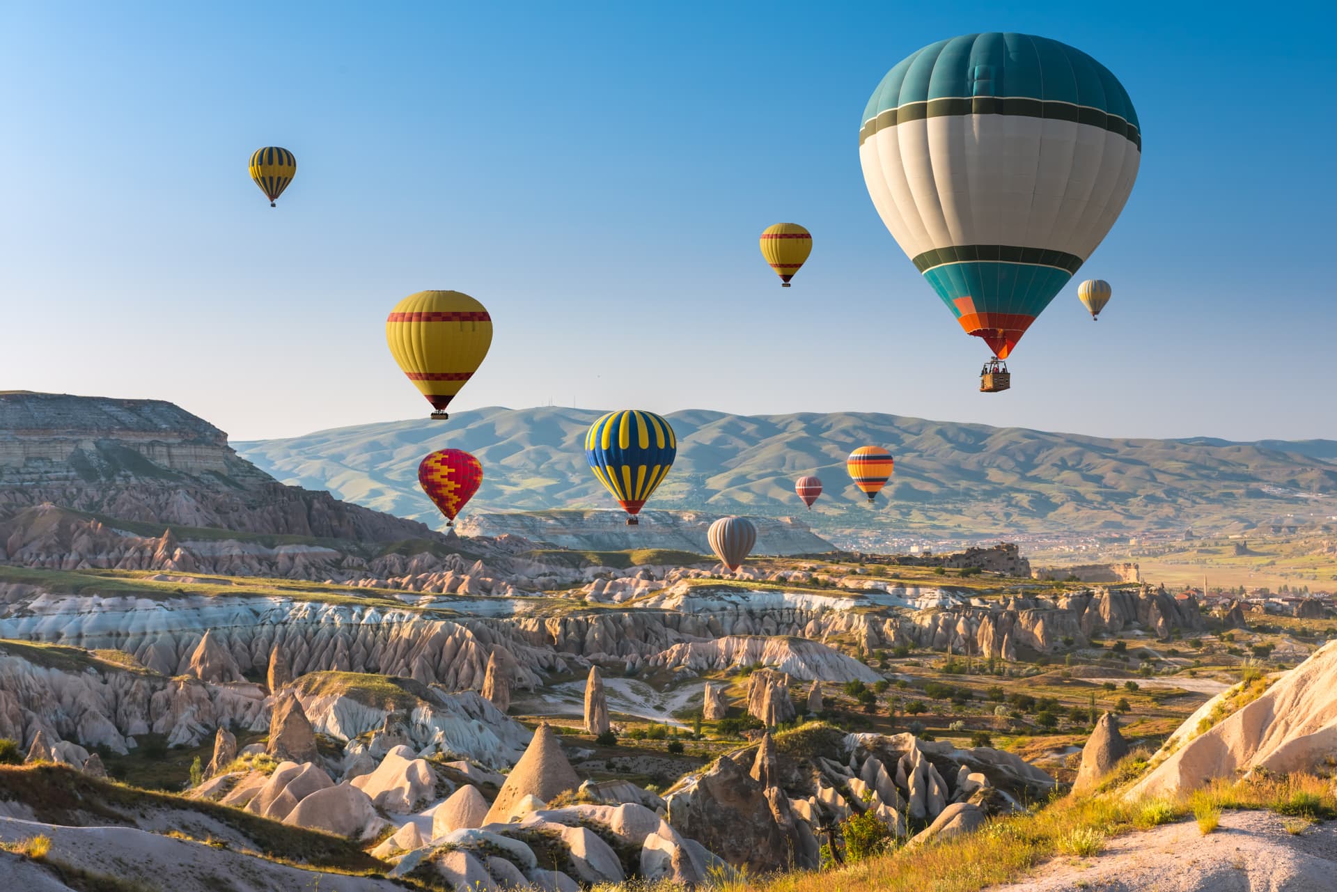 Hot air balloons flying over fairy chimneys and valleys in Cappadocia, Turkey