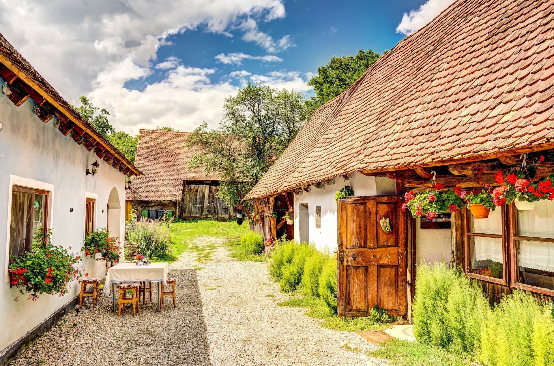 Traditional white houses with terracotta tile roofs and flower boxes on a sunny day.