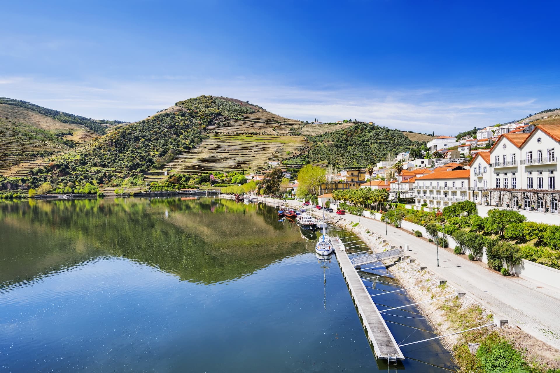 Pinhao town with Douro river, terraced vineyards, and white buildings in Douro Valley, Portugal.