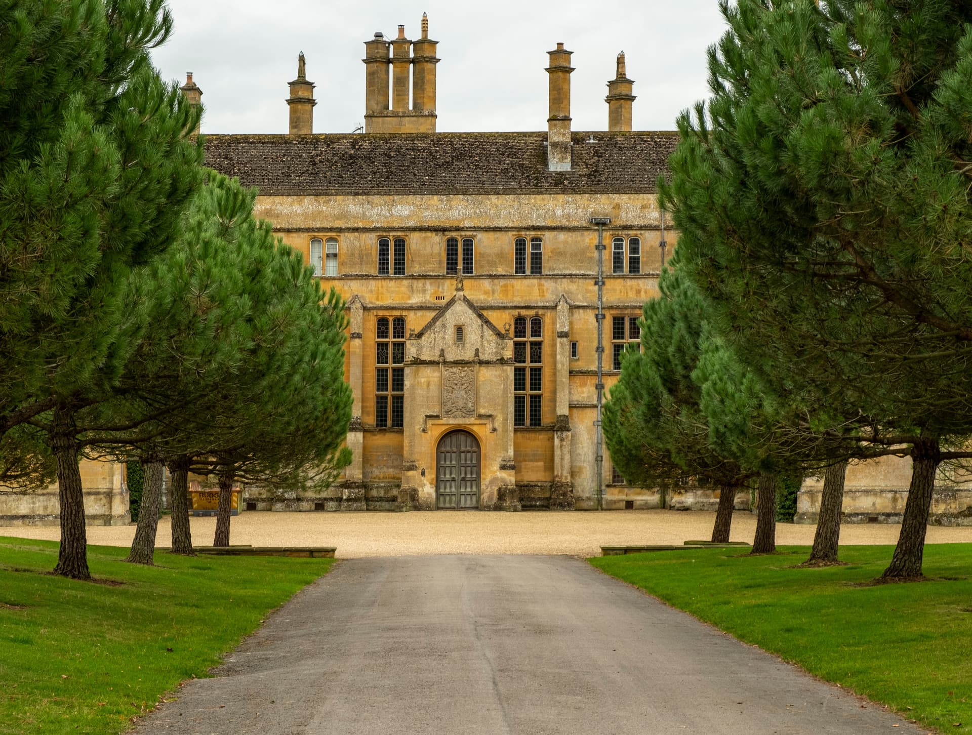 Batsford House in Moreton-in-Marsh, Cotswolds, viewed down an avenue of pine trees.