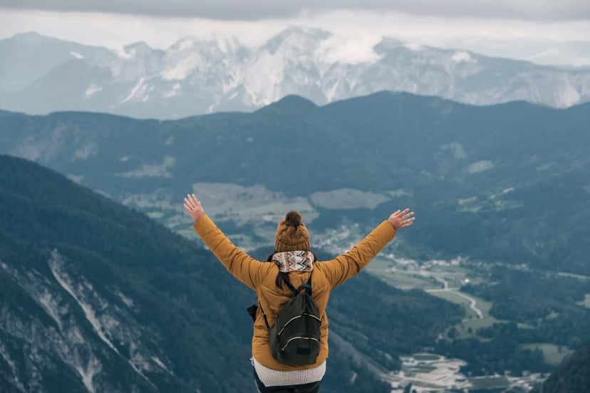 A hiker with outstretched arms at Slemenova spica in the Julian Alps - the concept of freedom