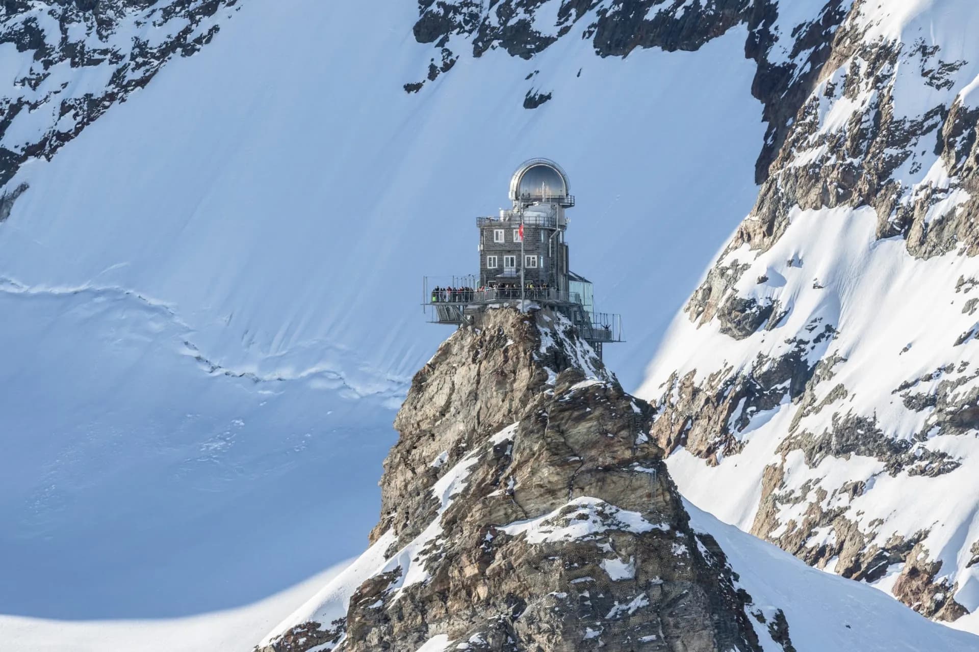 Sphinx Observation Deck on rocky peak surrounded by vast snowfields at Jungfraujoch.